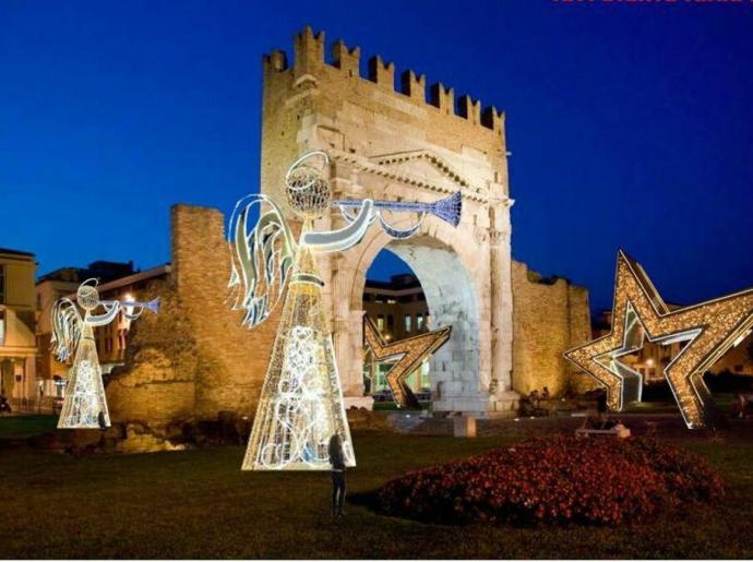 Decorazioni natalizie luminose davanti ad un antico arco romano.