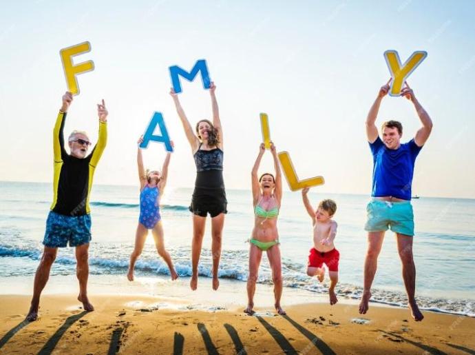 Happy family jumps on the beach holding colorful letters.