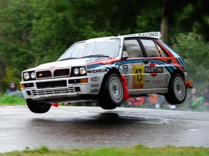 Auto da rally in volo durante una gara su strada bagnata.