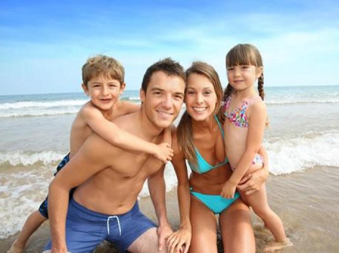 Famiglia felice in spiaggia con due bambini.